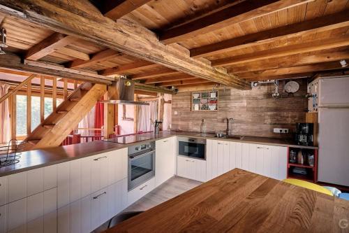 eine Küche mit weißen Schränken und einer Holzdecke in der Unterkunft Le Forgite - Gîte de charme in Matagne-la-Petite