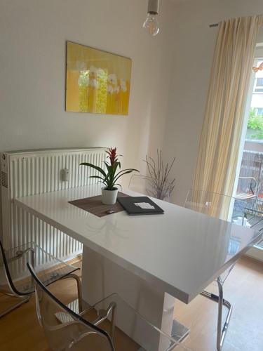a white table with a plant sitting on top of it at City Apartment Dresden in Dresden