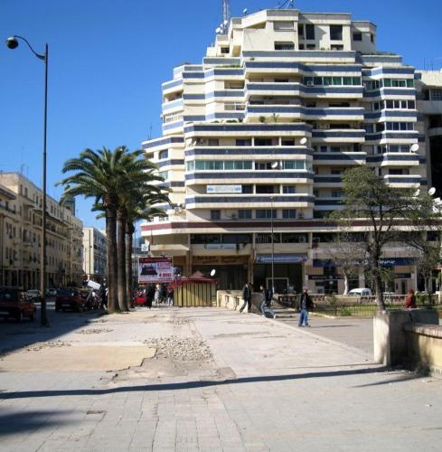 um grande edifício branco com uma palmeira em frente em Chez abdessalam em Fez