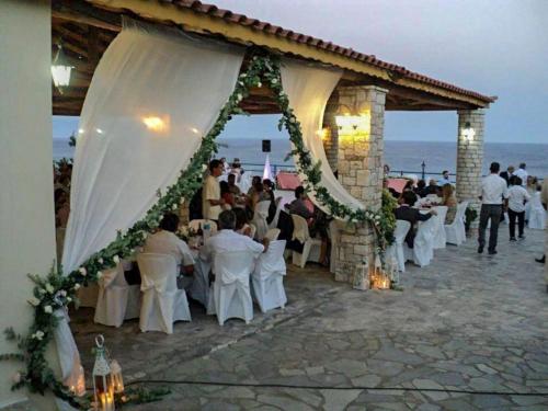 a group of people sitting at tables in a pavilion at De La Plage Hotel Koroni in Koroni