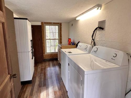 a laundry room with two washes and a refrigerator at Boozy Bear Bungalow romantic cabin 5 mins 2 downtown with hot tub and fire pit in Gatlinburg