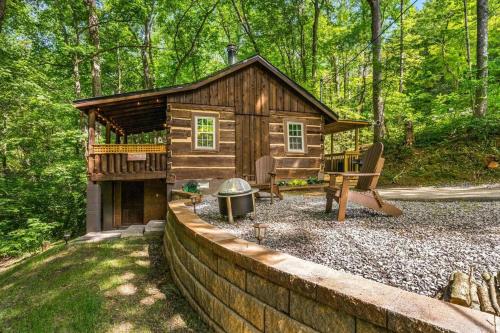 a log cabin in the woods with a fire pit at Boozy Bear Bungalow romantic cabin 5 mins 2 downtown with hot tub and fire pit in Gatlinburg