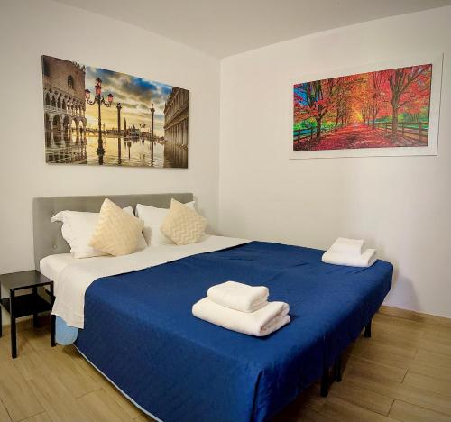 una camera da letto con un letto blu e asciugamani di CASA BANON a Venezia