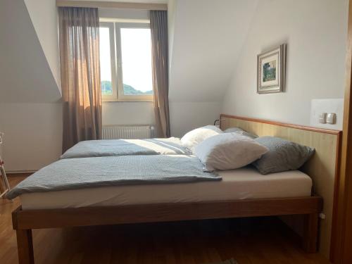 a bed with two pillows on it in a bedroom at Karla’s House in Dobje pri Planini