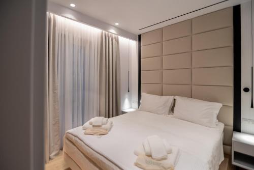 - une chambre avec un lit et 2 serviettes dans l'établissement Contessa Bianca Luxury Suites, à Corfou