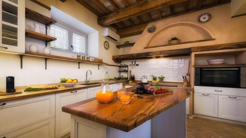 a kitchen with a wooden counter with two glasses on it at VILLA FLAMINIA 8&2 - Emma Villas in Gualdo Cattaneo