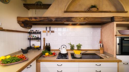 a kitchen with a sink and some vegetables on the counter at VILLA FLAMINIA 8&2 - Emma Villas in Gualdo Cattaneo