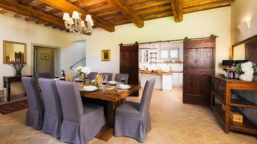 a dining room with a wooden table and chairs at VILLA FLAMINIA 8&2 - Emma Villas in Gualdo Cattaneo