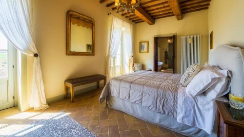 a bedroom with a bed and a mirror and a window at VILLA FLAMINIA 8&2 - Emma Villas in Gualdo Cattaneo