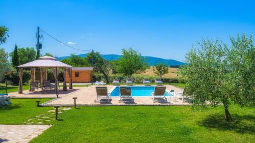 a swimming pool with chairs and a gazebo at VILLA FLAMINIA 8&2 - Emma Villas in Gualdo Cattaneo