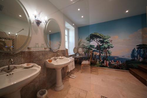 een badkamer met 2 wastafels en een grote spiegel bij MAISON D'HOTES LA GOURGUILLE in Barjac