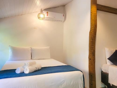 a small room with a bed with towels on it at Pousada Raiz Forte in Caraíva