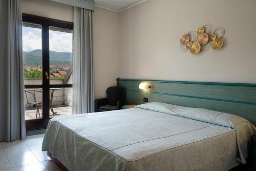 a hotel room with a bed and a balcony at Hotel Pian del Sole in Sassello