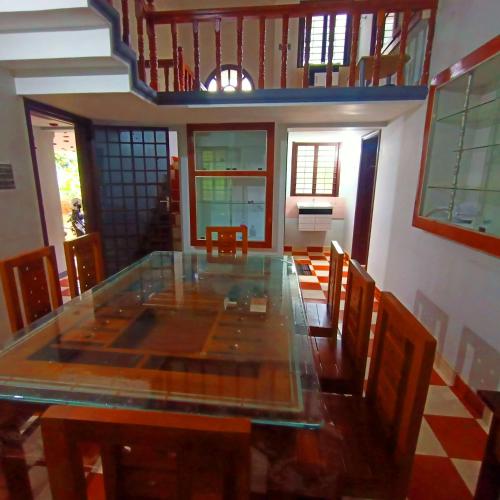 a dining room with a glass table and chairs at Wayanad Empire Villa in Kalpetta