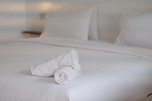 - un rouleau de serviettes blanches assises sur un lit dans l'établissement Jasmine Resort, à Buriram