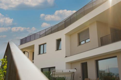a house with a balcony and a fence at Auszait Apartments 1 in Caldaro