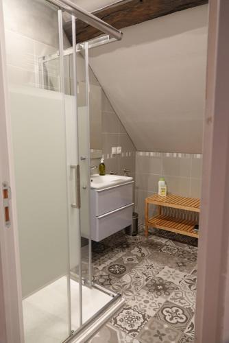 a bathroom with a white sink and a floor at B&B Les hirondelles du moulin, Val de Loire in Sassay
