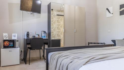 a bedroom with a bed and a desk with a television at -Le stanze dei Pico- Wi-Fi, nel cuore di Mirandola - una terrazza unica sul tetto in Mirandola