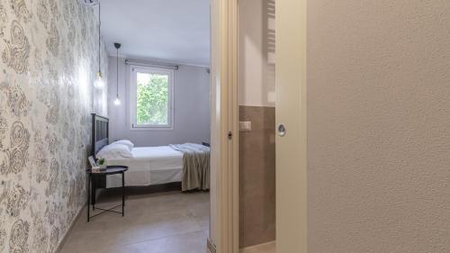 a bedroom with a bed and a window and a door at -Le stanze dei Pico- Wi-Fi, nel cuore di Mirandola - una terrazza unica sul tetto in Mirandola