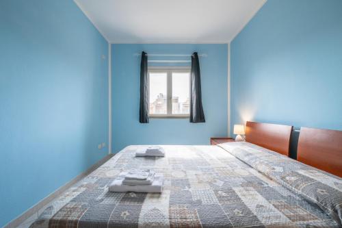 a blue bedroom with a large bed and a window at Casa Murru in SantʼAntìoco