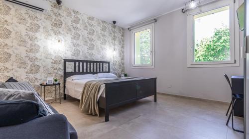 a bedroom with a bed and a tv and two windows at Le stanze dei Pico Wi-Fi, Netflix e una terrazza unica sul tetto in Mirandola