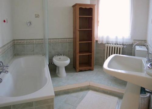 a bathroom with a tub and a toilet and a sink at Villa Mare in Forte dei Marmi