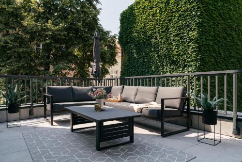 a patio with a couch and a coffee table at MUSE - LoftAffair Collection in Kraków