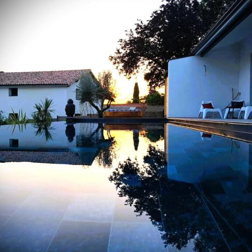 a swimming pool in front of a house at Loft & spa d'Autan in Villefranche-de-Lauragais