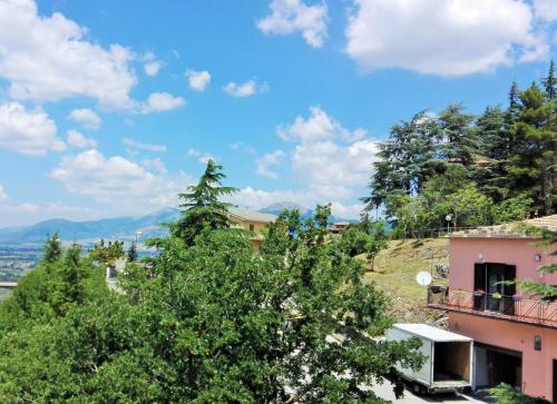 a building on a hill with trees in the foreground at Albergo Grumentum in Grumento Nova