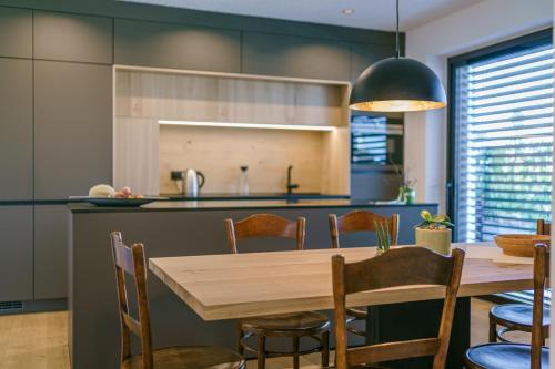 a kitchen and dining room with a wooden table and chairs at Auszait Apartments 1 in Caldaro
