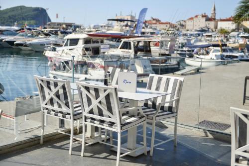 una mesa y sillas sentadas en un muelle con barcos en Luxury Hotel Riva - Budva en Budva