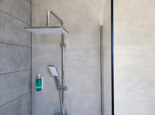 a shower with a shower head in a bathroom at Cabañas Alcobas do Sil Ecoturismo in Parada del Sil