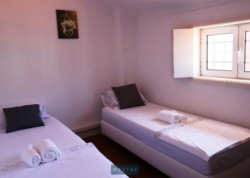 two beds in a room with a window at MyStay - Lira's Guest House in Porto