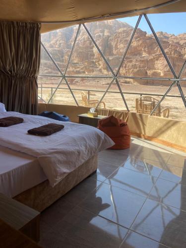 a room with a bed and a large window at Bilal luxury camp in Disah