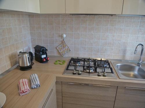 a kitchen counter with a stove and a sink at Wind Rose House - bicamere, parcheggio fronte mare in Grado