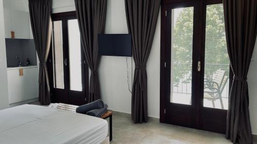 um quarto com uma cama e portas de vidro deslizantes em Athos Cape em Pyrgadikia