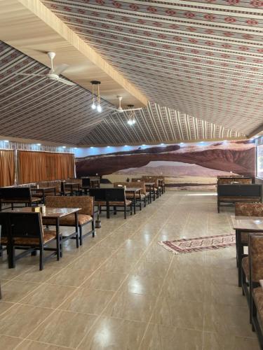 een eetkamer met tafels en stoelen en een plafond bij Bilal luxury camp in Wadi Rum