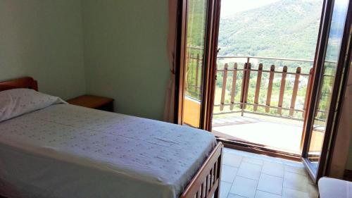 a bedroom with a bed and a large window at Albergo Grumentum in Grumento Nova