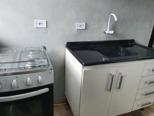 a kitchen with a sink and a stove at Kitnets Aconchegantes Próximo ao Shopping in Curitiba