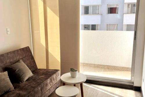 - un salon avec un canapé, une table et une fenêtre dans l'établissement Apartamento nuevo centro histórico!, à Manizales