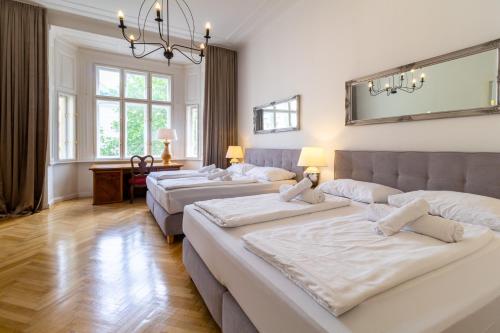 eine Gruppe von 4 Betten in einem Zimmer in der Unterkunft Large Luxury Residence Near Townhall & Votivkirche in Wien
