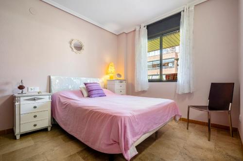 ein Schlafzimmer mit einem rosa Bett und einem Fenster in der Unterkunft Salou Centro in Salou