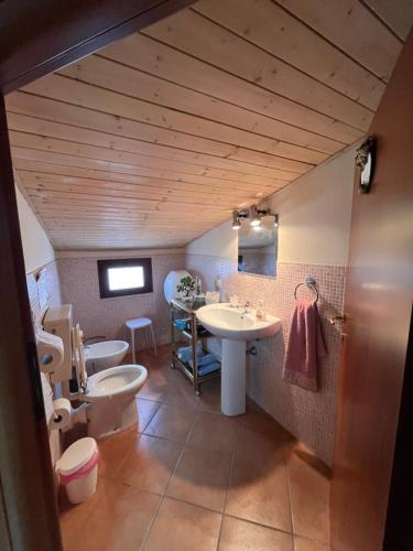 een badkamer met 2 toiletten, een wastafel en een toilet. bij Appartamento con due camere da letto in Quartu SantʼElena