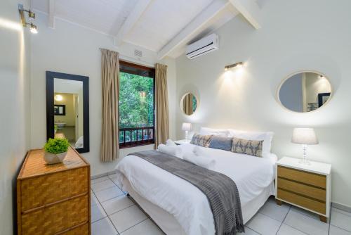 a bedroom with a large white bed and a window at San Lameer Villa 3014 - 3 Bedroom Classic - 6 pax - San Lameer Rental Agency in Southbroom