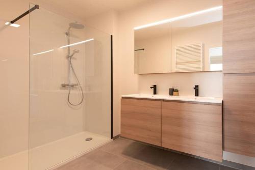 y baño con ducha, lavabo y bañera. en Luxe appartement met frontaal zeezicht bij Casino, en Ostende