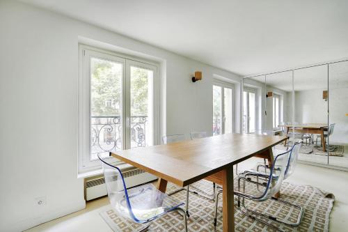 une salle à manger avec une table et des chaises en bois dans l'établissement Pick A Flat's Apartment in Saint-Germain - Rue du Bac, à Paris