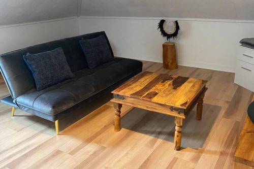 a living room with a couch and a coffee table at Logement au Cœur du Village in Saint-Jean-Port-Joli