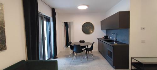 a kitchen with a table and chairs and a clock on the wall at Marisabella Suite Spa 2 in Bari