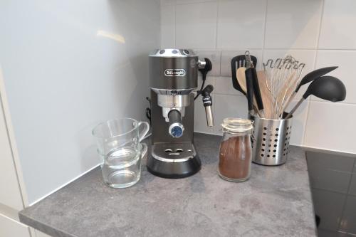 a kitchen counter with a coffee maker and a glass at Cowes Town House in Cowes