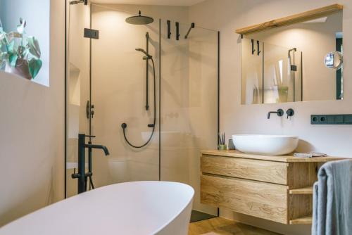 Un baño con bañera, lavabo y ducha. en Auszait Apartments 2, en Caldaro